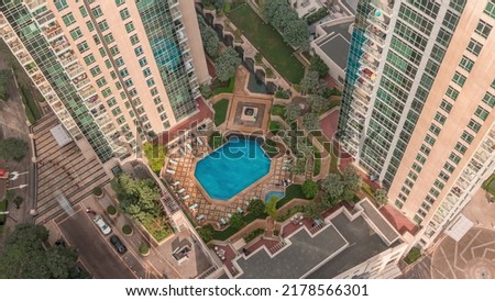 Resting area among skyscrapers with swimming pool and sunbed in Dubai downtown timelapse. Aerial top view from above. Look down perspective Royalty-Free Stock Photo #2178566301