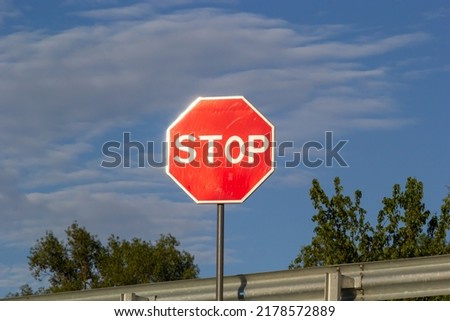 Red Stop Sign with Blue Sky and Clouds Background of the road.