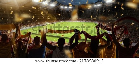 Support. Back view of football, soccer fans cheering their team with colorful scarfs at crowded stadium at evening time. Concept of sport, cup, world, team, event, competition Royalty-Free Stock Photo #2178580913