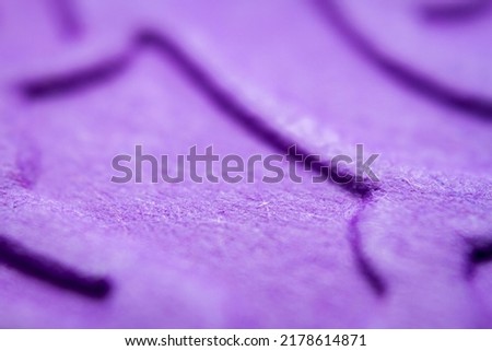 Extreme macro of embossed purple paper. Selective focus, shallow depth of field.