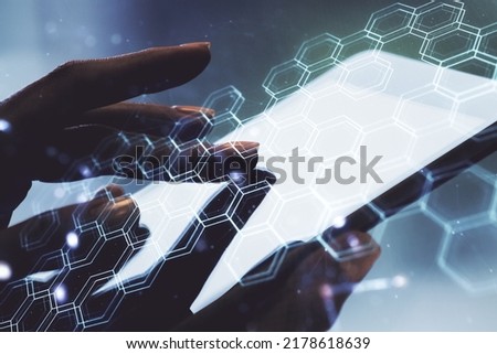 Double exposure of technology hologram with hexagon and finger clicks on a digital tablet on background. Research and development software concept