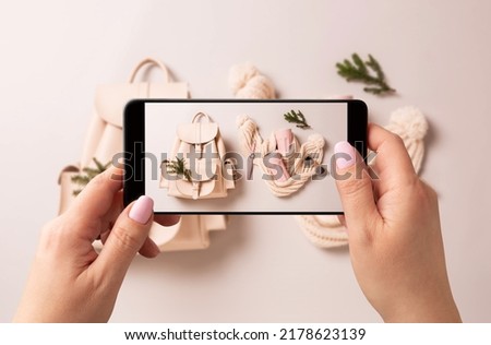 Woman taking photo of winter fashion accessories with smartphone. Blogger, influencer or stylist capturing Christmas gifts ideas for social media.