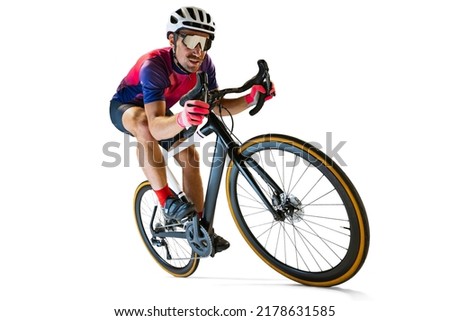 Portrait of man, professional cyclist training, riding isolated over white studio background. Concentration. Concept of sport, action, motion, speed, hobby, lifestyle. Copy space for ad Royalty-Free Stock Photo #2178631585