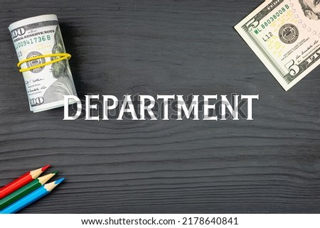 DEPARTMENT - word (text) on a dark wooden background, dollars and colored pencils. Business concept (copy space).