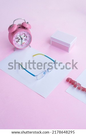 Fashion and beauty concept lying flat with square glasses, women's accessories on pink background. Product Presentation of Minimalist Concept Ideas
