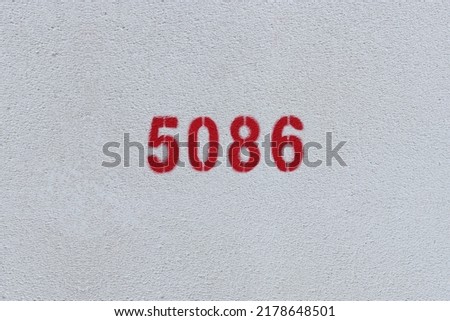 Red Number 5086 on the white wall. Spray paint.
