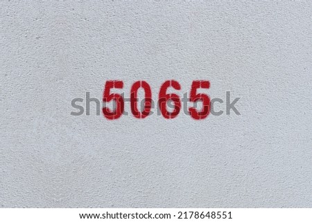 Red Number 5065 on the white wall. Spray paint.
