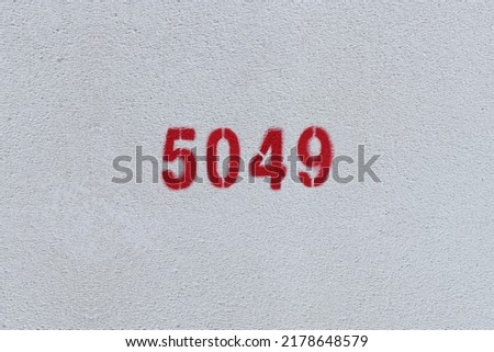 Red Number 5049 on the white wall. Spray paint.
