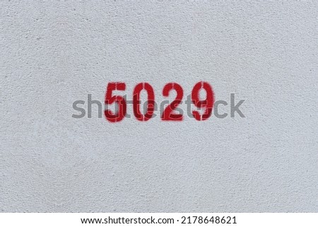 Red Number 5029 on the white wall. Spray paint.

