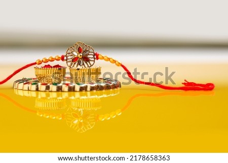 Indian festival raksha bandhan: puja thali and rakhi or wrist band on yellow background. Royalty-Free Stock Photo #2178658363