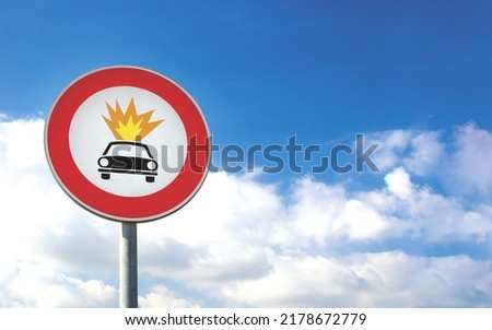 Round car sign transit prohibited for vehicles carrying explosive substances on a blue sky background. Car road sign, prohibition red sign.