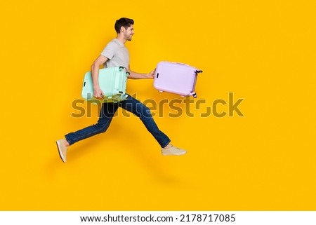 Full body photo of nice brunet young guy run with bag wear t-shirt jeans footwear isolated on yellow background