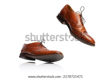 Flying man's brown classic style shoes over white background. Vintage dress shoes. Concept of ad, sales, 60s fashion, retro vintage style. Copy space for ad, design, text Royalty-Free Stock Photo #2178721471