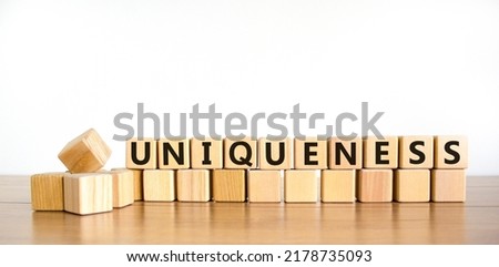 Uniqueness symbol. The word Uniqueness on wooden cubes. Beautiful wooden table, white background. Business and uniqueness concept. Copy space.