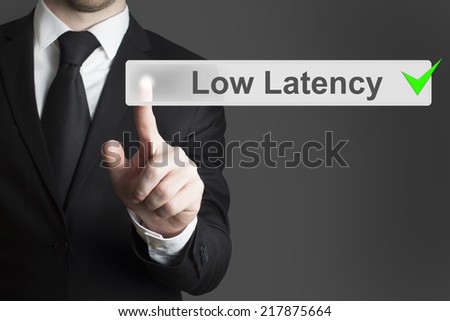 businessman in black suit pushing virtual button low latency