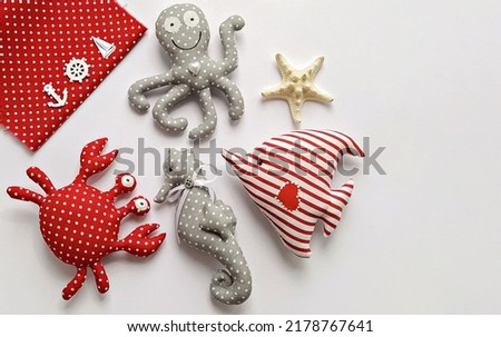 Handmade cartoon stuffed toys in hand, sea life octopus, crab, fish and seahorse. Toy crab, octopus, starfish, seahorse, and fish. DIY Flat lay