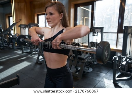 Woman doing weight training in fitness club Royalty-Free Stock Photo #2178768867