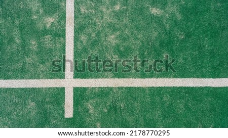 Top view of line on floor and part of green synthetic grass paddle tennis court indoor without people. Padel is a racquet game. Professional sport concept with copy space for text