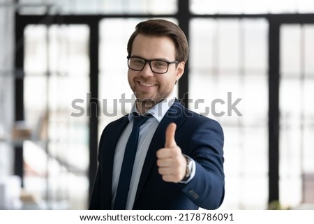 Head shot portrait smiling businessman wearing suit and glasses showing thumb up and looking at camera, successful employee or hr manager recommending company service, giving recommendation Royalty-Free Stock Photo #2178786091
