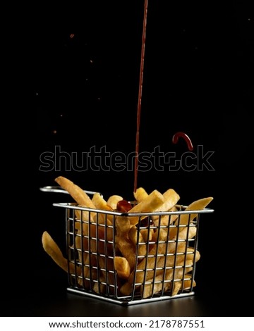 Picture of French fries with BBQ sauce on a suitable black background
