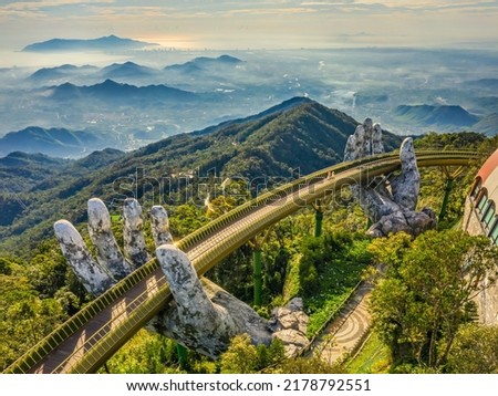 Aerial view of the Golden Bridge is lifted by two giant hands in the tourist resort on Ba Na Hill in Da Nang, Vietnam. Ba Na mountain resort is a favorite destination for tourists Royalty-Free Stock Photo #2178792551