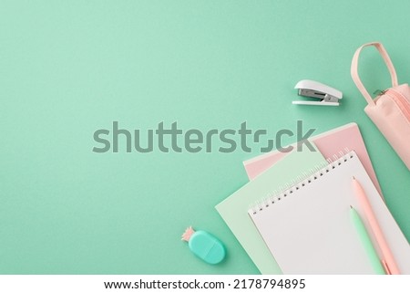 School supplies concept. Top view photo of stylish stationery notebooks pineapple shaped eraser pens pink pencil-case and mini stapler on isolated pastel green background with copyspace Royalty-Free Stock Photo #2178794895