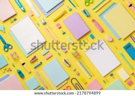 Top view photo of school supplies notebooks pencils correctors marker pens binder clips stapler calculator ruler adhesive tape scissors sharpener eraser sticky note paper on isolated yellow background Royalty-Free Stock Photo #2178794899