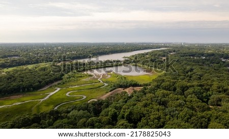An aerial drone shot high above a green and grassy marshlands on a sunny day on Long Island, NY. Royalty-Free Stock Photo #2178825043
