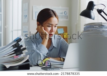 Tried Asian office employee feeling bored, unhappy and burnout working in office Royalty-Free Stock Photo #2178878335