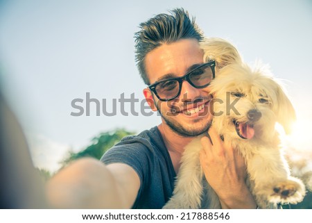 Young handsome man taking a selfie with his dog Royalty-Free Stock Photo #217888546