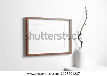 Horizontal wooden frame mockup on white wall with copy space for artwork, photo, painting or print presentation.