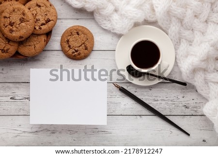 Mockup piece of paper for text or picture, coffee, cookies and sugar on gray wooden background.