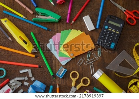 flat lay colorful creative, craft and office supplies on wooden table