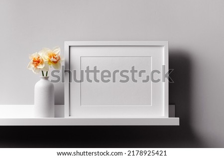 Landscape frame mockup on shelf with daffodils flowers, minimalistic interior mockup