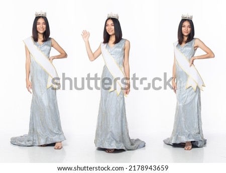 Full length of Miss Beauty Pageant Contest wear blue gray evening sequin gown with diamond crown sash, Asian female stand express feeling happy smile over white background isolated Royalty-Free Stock Photo #2178943659