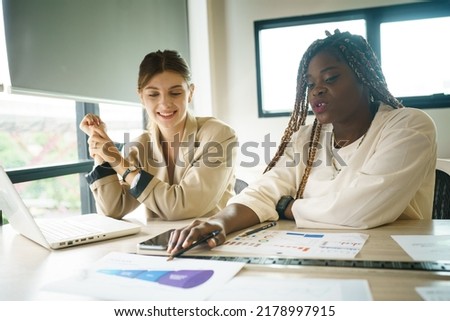 Young African American businesswoman lead meeting with multiethnic colleagues, communicate interact in office. Female ethnic coach or boss present at workplace, brainstorm with diverse businesspeople.