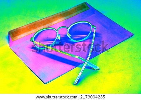 The glasses are in an open envelope. Corporate desktop, receiving correspondence. The concept of loneliness, the thirst for communication. Changed color scheme