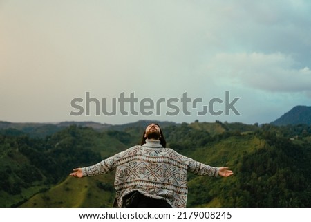 young latin man with long hair with open arms, meditating and breathing deeply consciously mindful