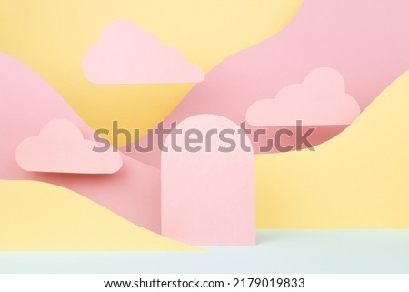 Tender fashion style paper abstract stage mockup - pink arch podium, pastel mountain landscape - yellow, mint color slopes, clouds. Template for advertising, presentation cosmetic produce, showcase.