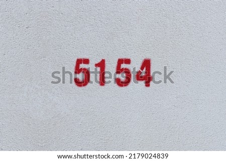 Red Number 5154 on the white wall. Spray paint.
