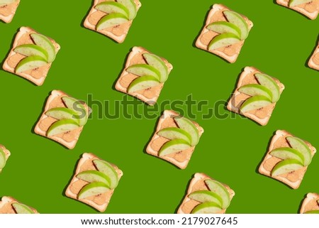 Pattern of toasted bread with apple and cinnamon on green background. High quality photo