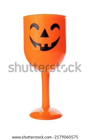 A cute orange cup with jack-o-lantern face isolated on white background. Halloween.