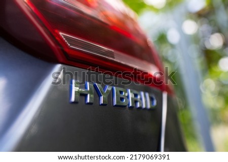 Close-up of Hybrid icon on car body. Environment concept. Ecological transport. Royalty-Free Stock Photo #2179069391