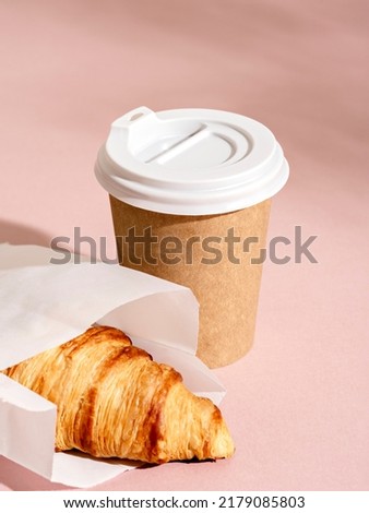 Coffee in a craft paper cup and croissant on pink background with  foliage shadow. Sunny urban scene with hard light and shadow. Breakfast to go, take away food concept. Royalty-Free Stock Photo #2179085803