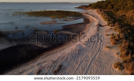 Aerial shot of person taking pictures of beautiful landscape with sandy islands, lake shore of Laguna Negra during sunset in Uruguay