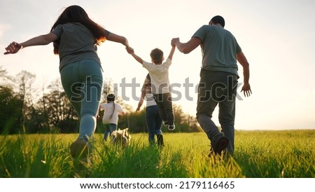 happy family running in the park in summer. mom and dad hold their son by the hands run throw up in the forest park on the grass in the summer. happy family lifestyle kid dream concept Royalty-Free Stock Photo #2179116465