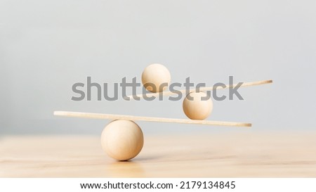 Wooden scale balancing on seesaw. Concept of harmony and balance in life and work Royalty-Free Stock Photo #2179134845