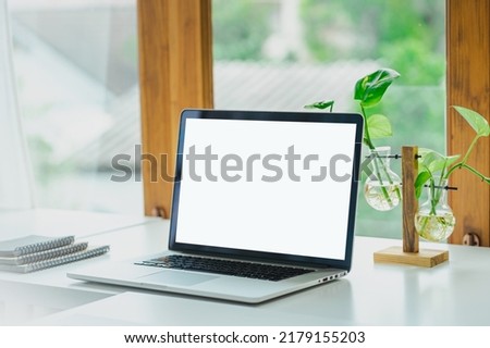 Stylish workspace with laptop computer, office supplies, plant.