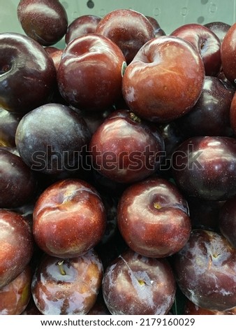 a group of fresh plums in supermarket