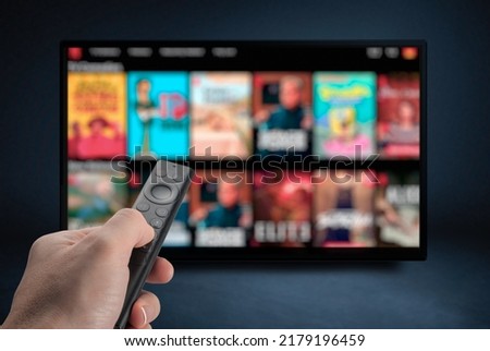 Tv online. Television streaming video. Media TV on demand. Online Multimedia video concept on TV set in dark room. Watching online TV with remote control in hand. Royalty-Free Stock Photo #2179196459